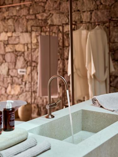 a bathroom sink with a faucet and a mirror at D3 Milos in Plaka Milou