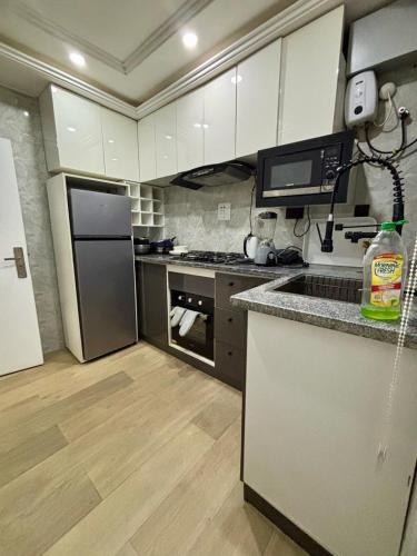 a kitchen with white cabinets and stainless steel appliances at Furnished two bedrooms at Wuye Abuja in Ankuru