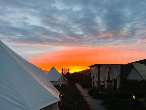 a group of tents with a sunset in the background at Nalati Jianxian B&B in Narat