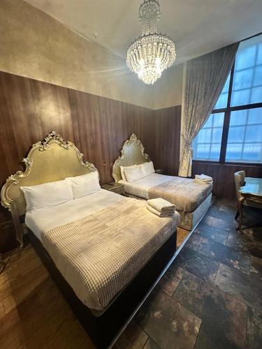a bedroom with two beds and a chandelier at White Star Line Hotel in Liverpool