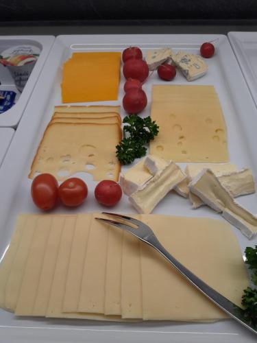 a plate with cheese and vegetables on a table at Lisas Schröcken in Schröcken