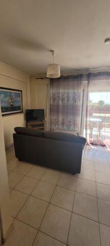a living room with a couch in front of a window at Ostria Seaside Apartments in Patra