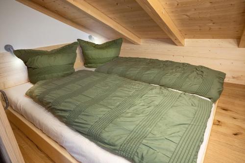 a large green comforter on a bed in a room at Stadlerhof Alpen- & Seeblick in Kirchanschöring