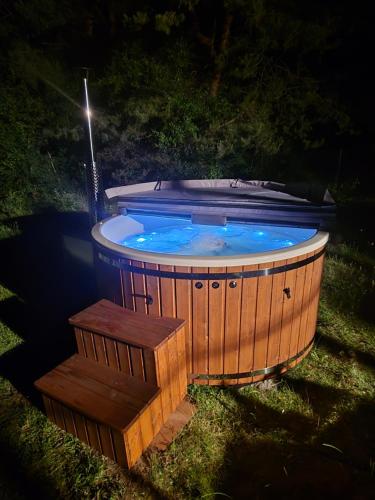 a jacuzzi tub in the yard at night at Dom w lesie in Łukta