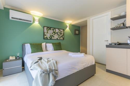 a bedroom with a bed and a green wall at CityZen - Boutique Studios in Achrafieh in Beirut
