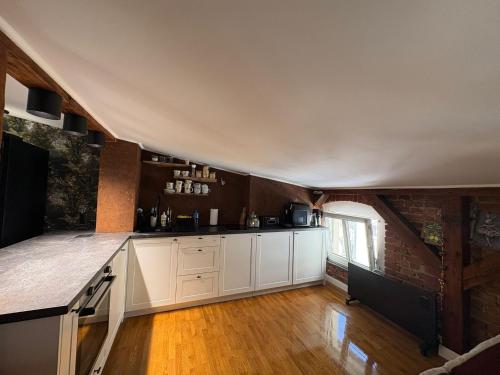 a kitchen with white cabinets and a brick wall at Apartament Wojciecha 9B 4 - Gdynia Śródmieście 70m2 Górne in Gdynia