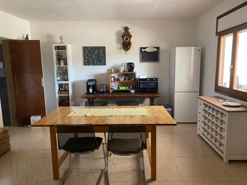 a kitchen with a wooden table and a refrigerator at RnR BednBreakfast in Caspe