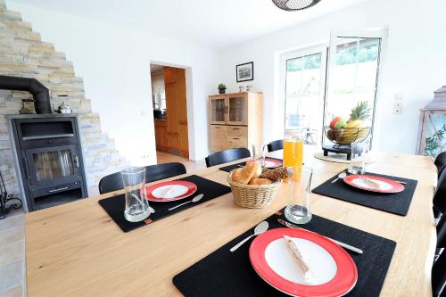 a dining room table with red and white plates on it at Flechtdorfer Waldblick - 130 qm großes Ferienhaus und großem Grundstück und Bachlauf und Terrasse für 6 Gäste in Diemelsee