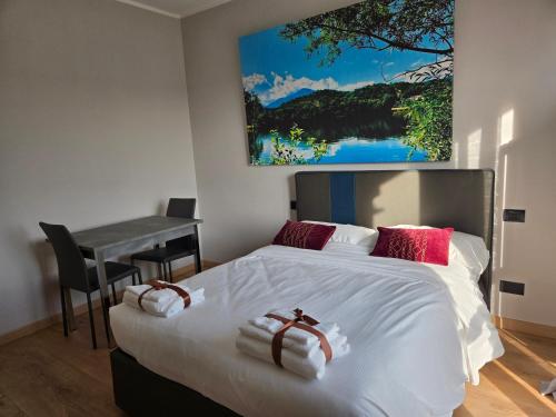 a bedroom with a bed with a desk and a painting on the wall at 7 LAKES Aparthotel in Burolo