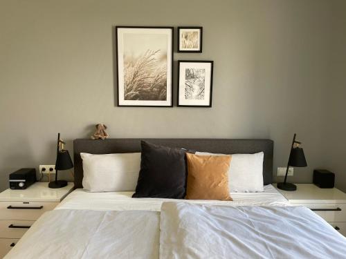 a bedroom with a bed with three pictures on the wall at Vinkennest am Diemelsee - Sonnenweg 44 - Kinderfreundliche Ferienwohnung mit Sauna, Terrasse, Garten und Seeblick! in Diemelsee