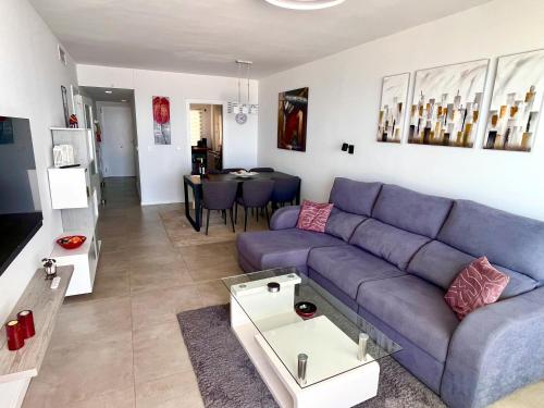 Una sala de estar con un sofá azul y una mesa. en Lovely New Luxery Beach Apartment in Mojacar Playa next to the best beach, en Mojácar