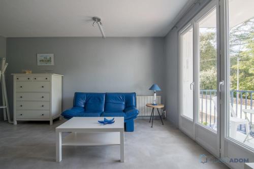 un salon avec un canapé bleu et une table dans l'établissement L'Air Marin - 300m de la plage - Parking, à Pornic