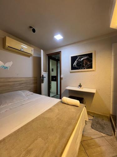 a bedroom with a large bed and a sink at Angel Hospedagem de quartos Self Check in in Vila Velha
