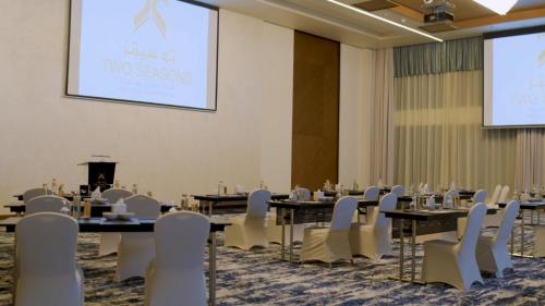 a conference room with tables and chairs and a podium at Two Seasons Hotel & Apartments in Dubai