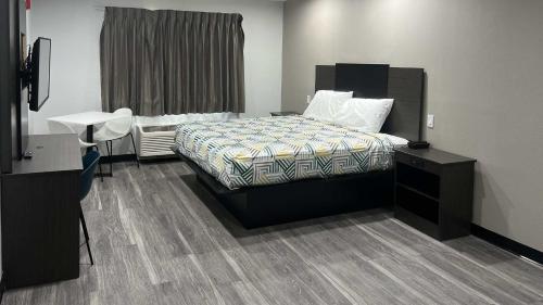 a bedroom with a bed and a dresser and a desk at Studio 6 Oklahoma City, OK South in Oklahoma City