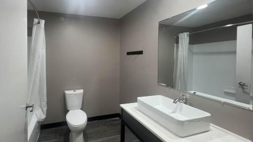 a bathroom with a sink and a toilet and a mirror at Studio 6 Oklahoma City, OK South in Oklahoma City