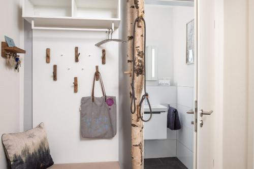 a bathroom with a door open with a bag on the wall at Ferienhaus Sonnenweg 32 - Sauna, Garten und Seeblick inklusive in Diemelsee