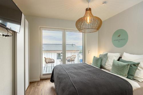 a bedroom with a bed with a view of a balcony at Ferienhaus Sonnenweg 32 - Sauna, Garten und Seeblick inklusive in Diemelsee