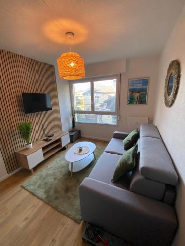 una sala de estar con un sofá y una mesa en Les Quais centre-ville, en Rennes