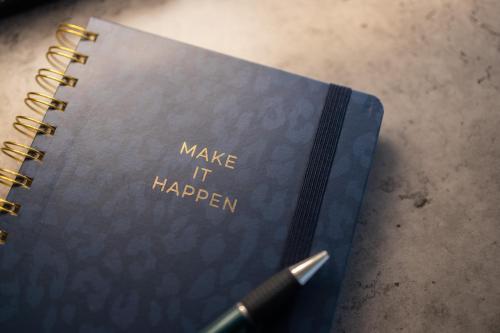 a notebook with the words make it happen with a pen at Dorumer Sielhuus 10 - Sauna und balkon, strandnah in Dorum