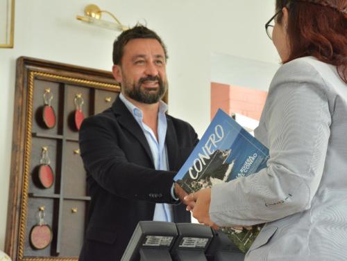 un hombre y una mujer sosteniendo un libro en Hotel Galassi, en Numana