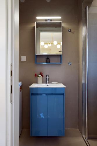 a bathroom with a blue sink and a mirror at Kanali Hill Studio in Kanálion