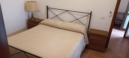 a bedroom with a bed and a dresser and a lamp at appartamentino Villa Elena in Grutti