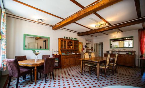 a dining room with two tables and chairs and a kitchen at Ambiance Morvan in Ouroux en Morvan