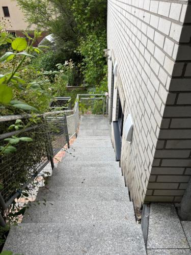 a sidewalk next to a building with a fence at UPGRADE - frisch renoviert - Ferienwohnung Monteuerswohnung am Bauernhofweg in Lohmar nahe S-Bahnhof Messe Flughafen in Lohmar