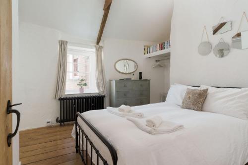 a bedroom with a large white bed with towels on it at Luxury Cornish Cottage & Modern Cabin with Garden, Central St Agnes in St. Agnes