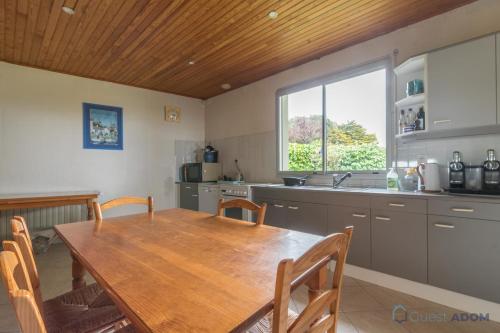une cuisine avec une table en bois et une grande fenêtre dans l'établissement La Vue Mer - 50m de la plage - Parking, à Pornic
