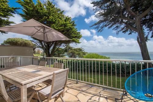 un patio avec une table et un parasol dans l'établissement La Vue Mer - 50m de la plage - Parking, à Pornic