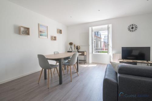 un salon avec une table, des chaises et un canapé dans l'établissement Le Cancalais - Port - Wifi - Plage, à Cancale