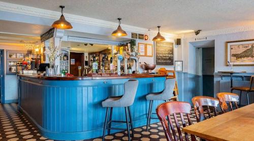 a bar in a restaurant with a blue bar at Luxury Cornish Cottage & Modern Cabin with Garden, Central St Agnes in St. Agnes