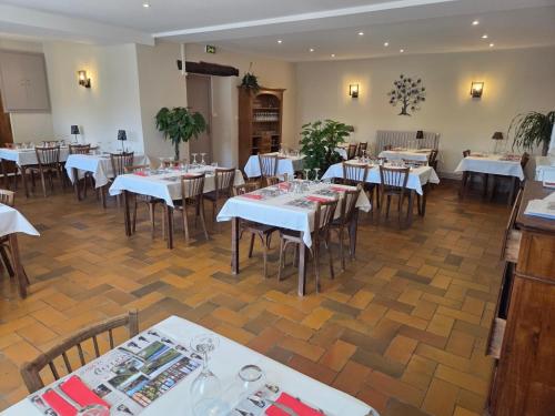 a dining room with white tables and chairs at L'Auberge de Julien et Magali in Arandas