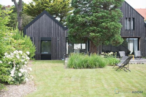 une maison noire avec un jardin en face dans l'établissement Sekoya Villa - Proche plage - golf, à Pornic
