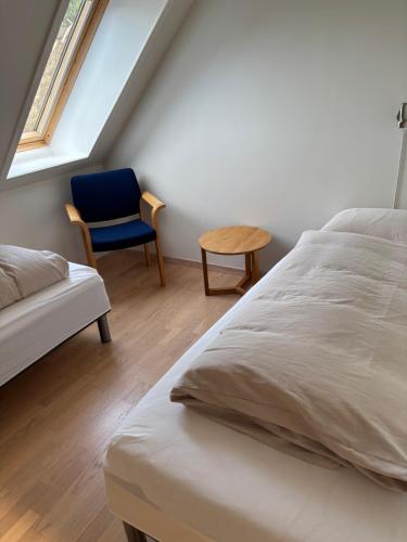 a bedroom with a bed and a chair and a window at Billund Rooms in Billund