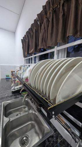 a kitchen with a sink and a drying rack at Abadi's Homestay in Tanjung Karang
