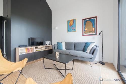 a living room with a couch and a table at Sekoya Lodge - Proche plage - golf in Pornic