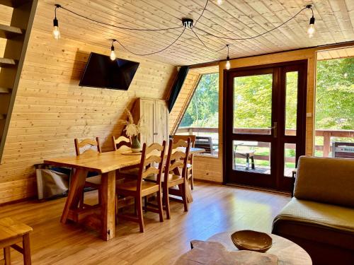 a dining room with a wooden table and chairs at Domki Wierzchy in Wierzchy
