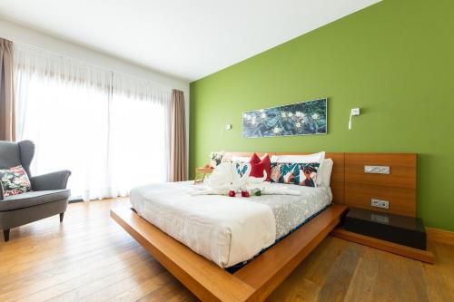 a bedroom with a large bed with green walls at Villas Mamma Mia pool heat Private & Jacuzzi in Playa Blanca