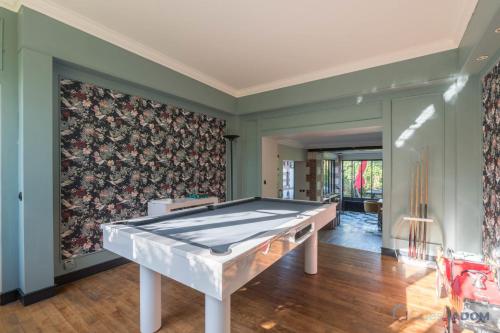 einen Billardtisch in einem Zimmer mit einer Wand in der Unterkunft L'Oasis - Proche plage - Wifi - Jardin in Pornic