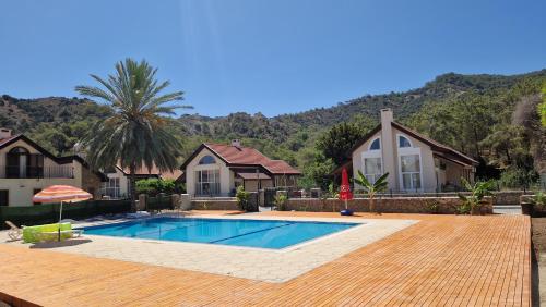 a house with a swimming pool in front of a house at Harmony Homes in Kérynia