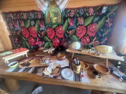 a table with plates and bowls of food on it at Pensiunea La Ancuța-n Bucovina in Voronet