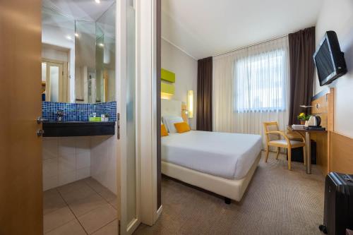a hotel room with a bed and a bathroom at iH Hotels Milano Gioia in Milan