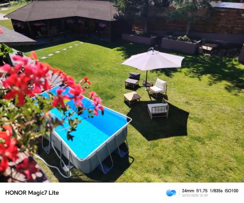 an overhead view of a swimming pool and an umbrella and chairs at Pensiunea La Ancuța-n Bucovina in Voronet