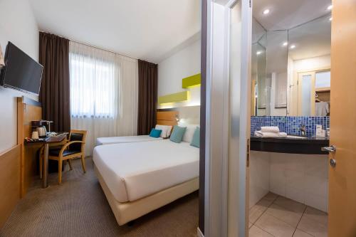 a hotel room with a bed and a bathroom at iH Hotels Milano Gioia in Milan