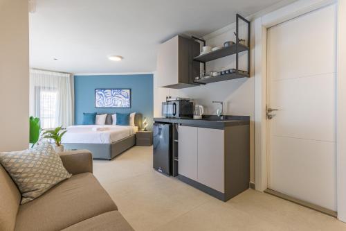 a living room with a couch and a kitchen with a bed at CityZen - Boutique Studios in Achrafieh in Beirut