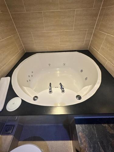 a bath tub with two faucets in a bathroom at White Star Line Hotel in Liverpool