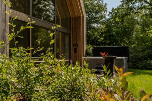 a screened in porch of a house with plants at Lodge met Jacuzzi - 6 personen - Woodz Lodges in Heusden - Zolder
